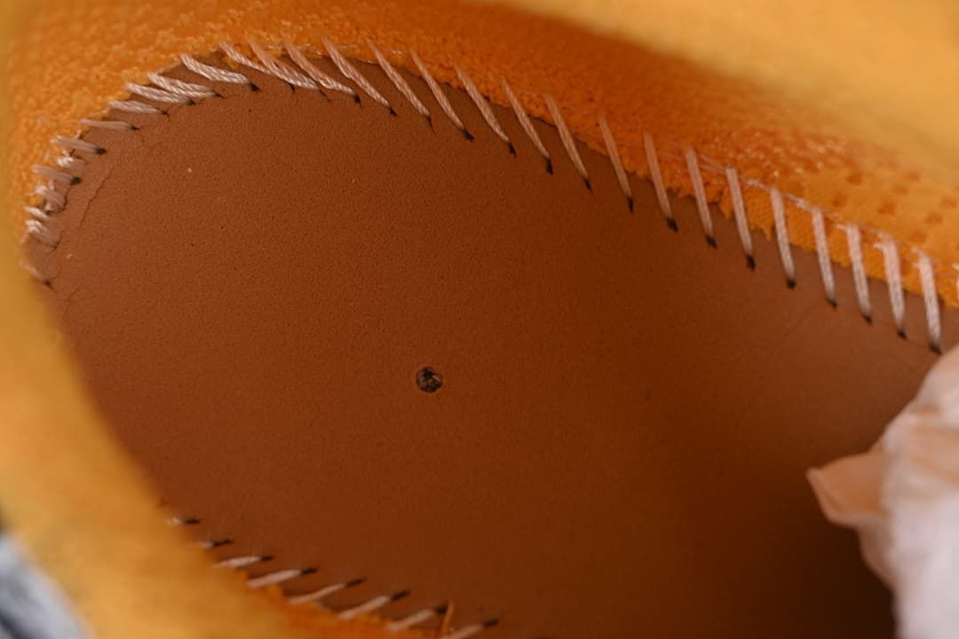 Close-up of stitching inside the orange-lined shoe