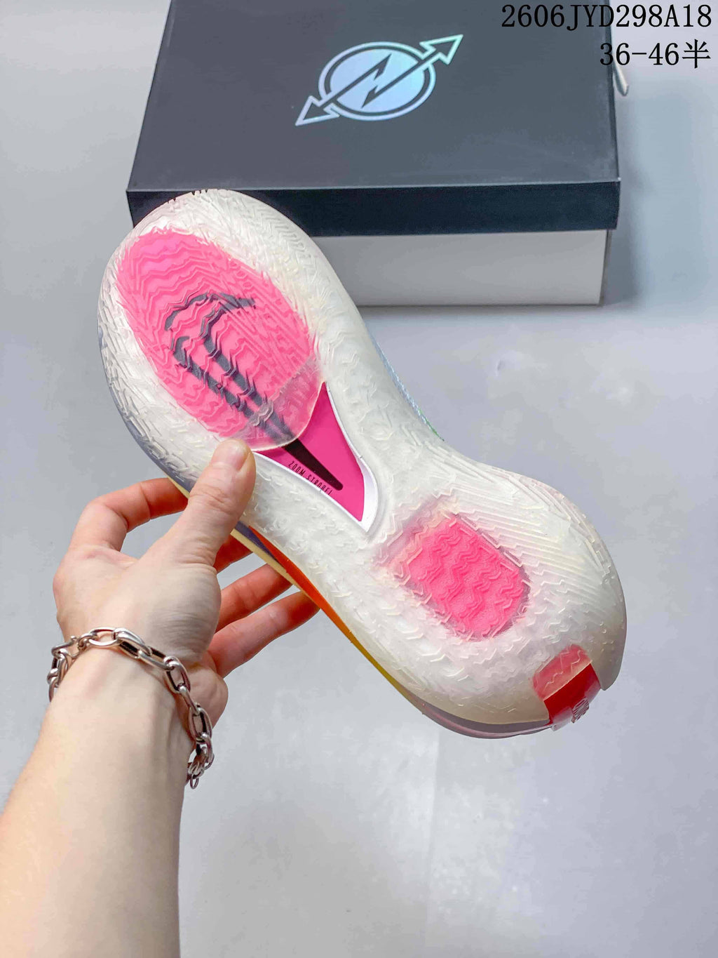 Underside of the shoe showing a translucent outsole with pink sections and tread pattern.