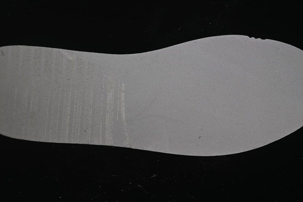 Underside of the sneaker midsole shown against a dark background