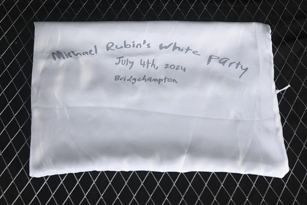 White fabric pouch with handwritten event text