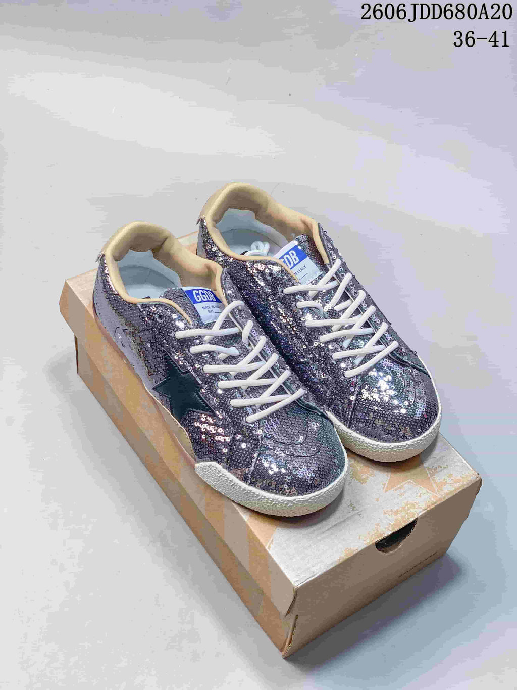 Pair of silver-toned sequin Golden Goose Super-Star low-top sneakers on a box