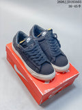 Pair of navy Nike Blazer sneakers with white patterned soles on a red shoe box