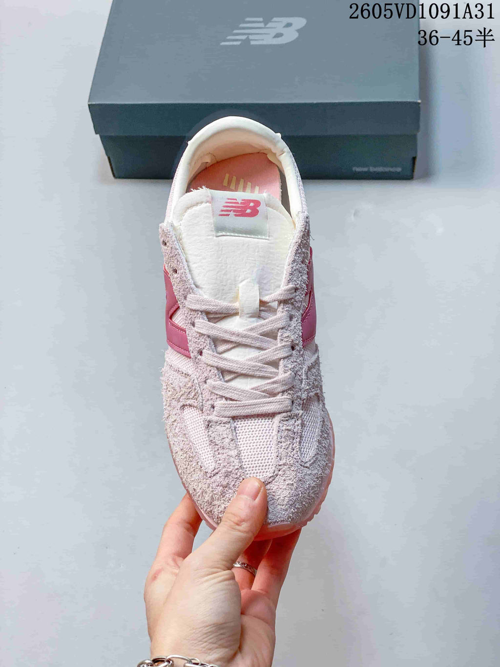 Top view of a pale pink New Balance 471 sneaker with lace-up fastening.