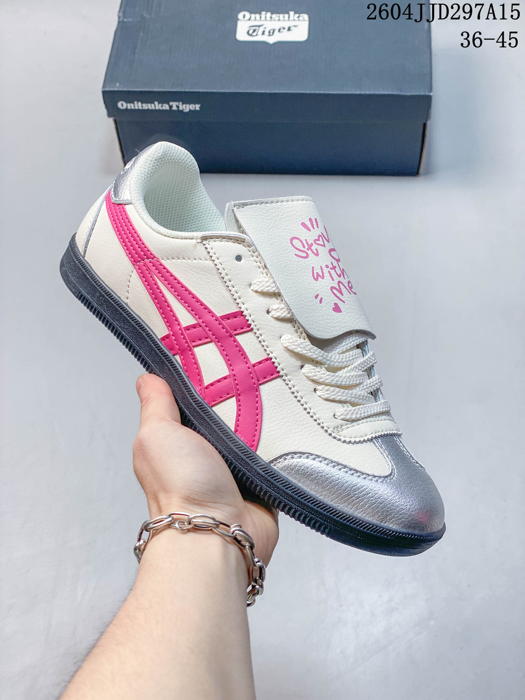 Cream low-top sneaker with bright pink side stripes and a silver-toned toe panel