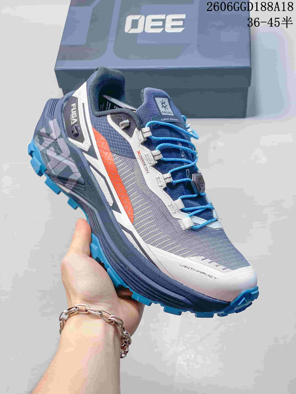 Angled view of the gray and navy trail shoe with blue laces and orange side accent