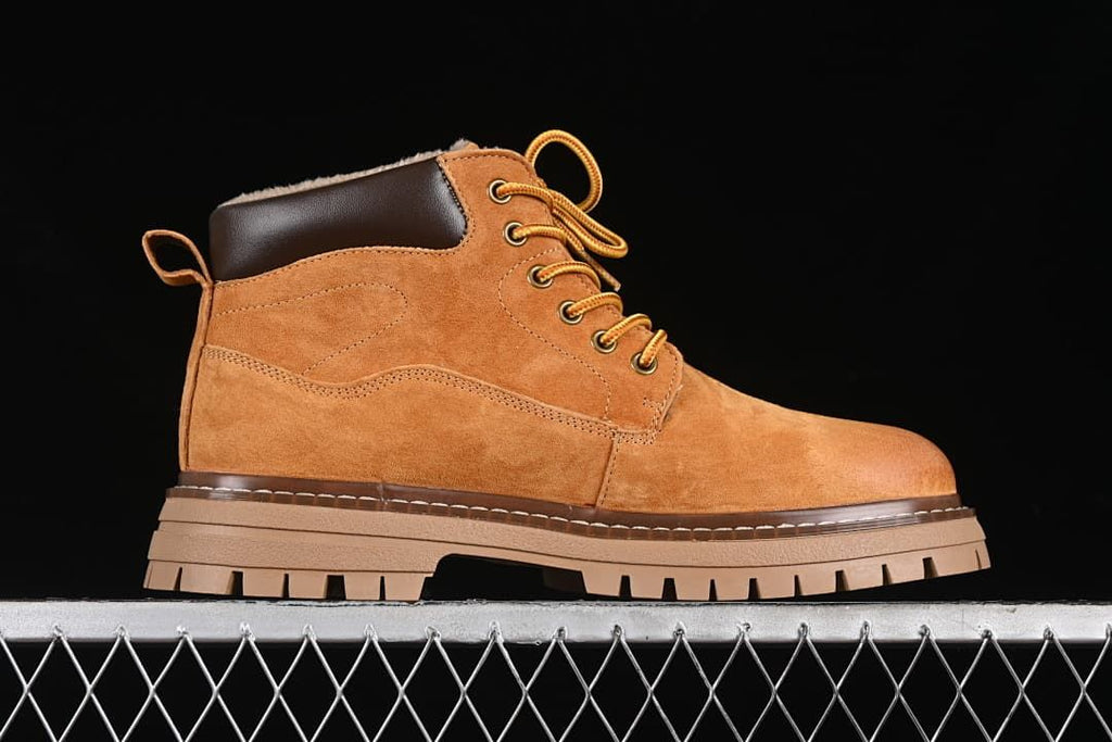 Side profile showing the boot’s yellow-brown upper and thick lugged outsole.