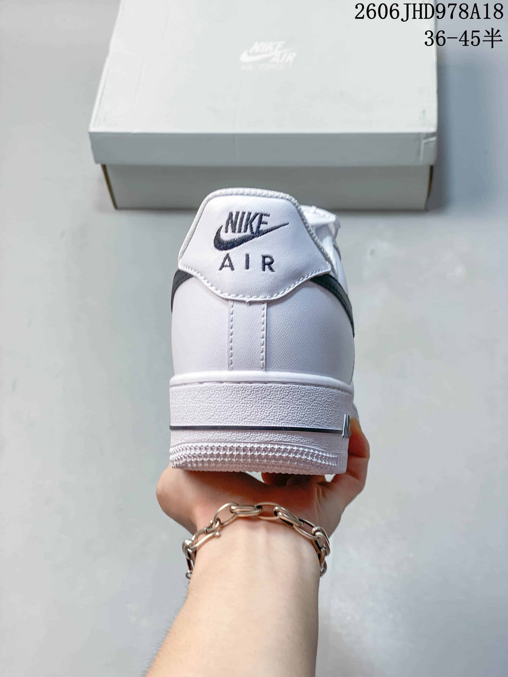 Rear view of the white sneaker showing Nike Air branding and heel stitching.