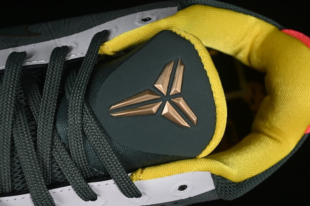 Close-up of the tongue emblem, dark laces, and yellow lining