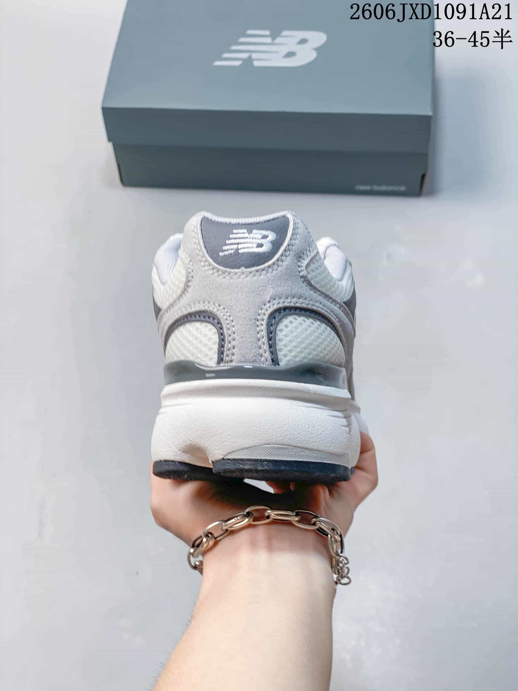 Rear view of a gray and white New Balance sneaker