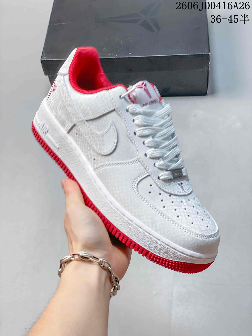 Close-up side view of a white textured low-top Nike Air Force 1 '07 sneaker with red lining and outsole.
