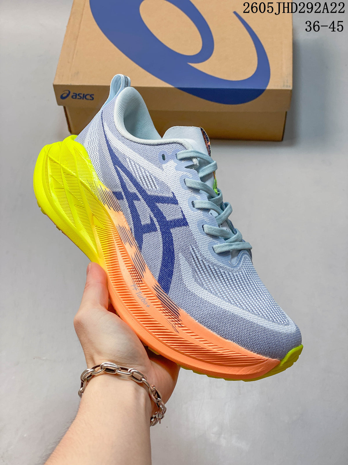 Pale blue ASICS Superblast 2 Paris running shoe with orange and fluorescent yellow accents.