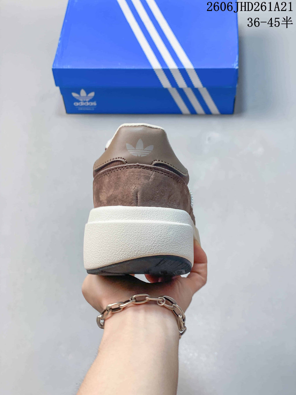 Rear view of the taupe sneaker with a raised off-white midsole