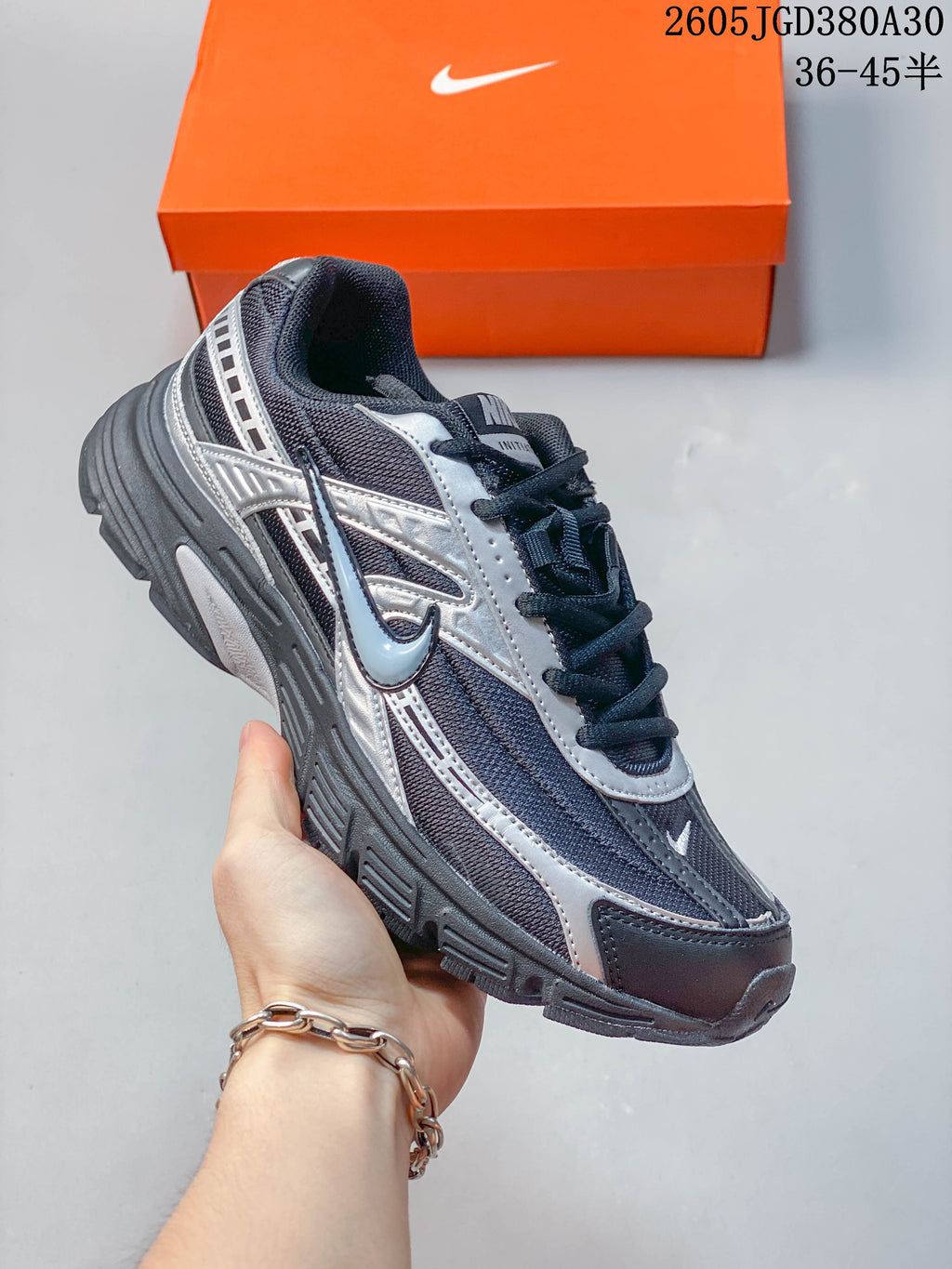Angled side view of a charcoal and silver Nike Initiator sneaker