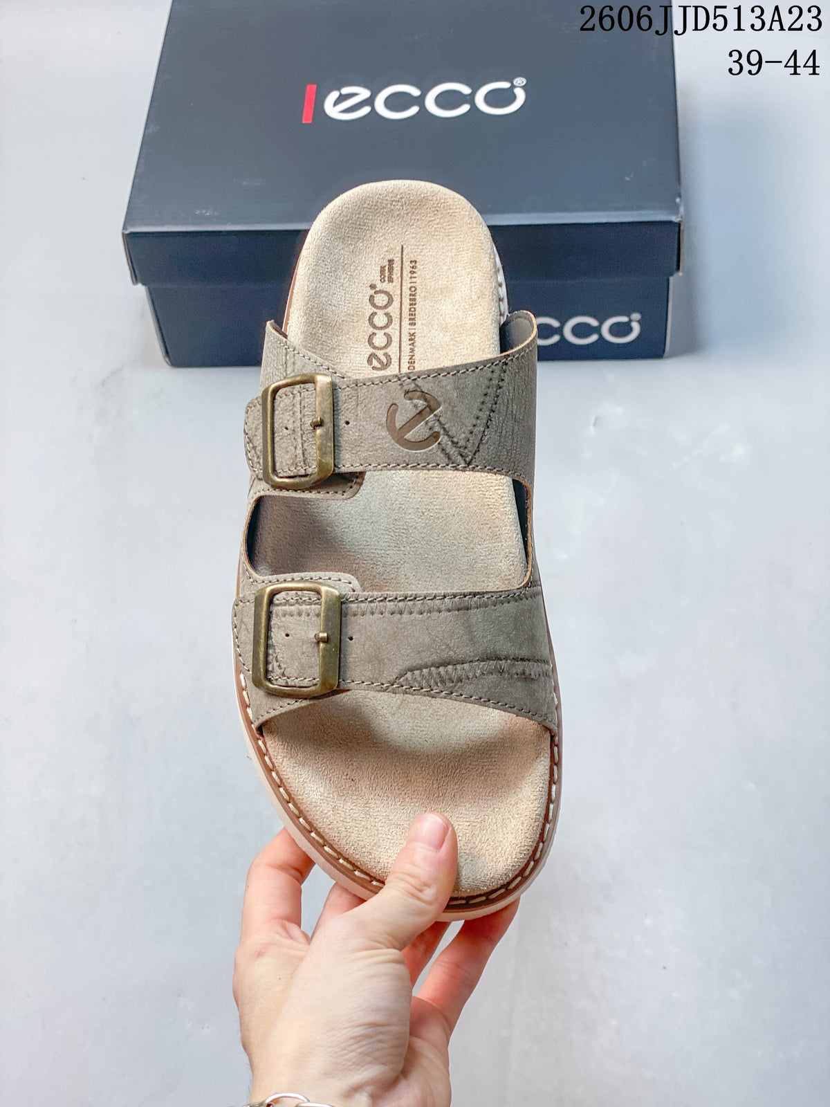 Top view of a taupe sandal showing its two adjustable buckle straps and footbed.