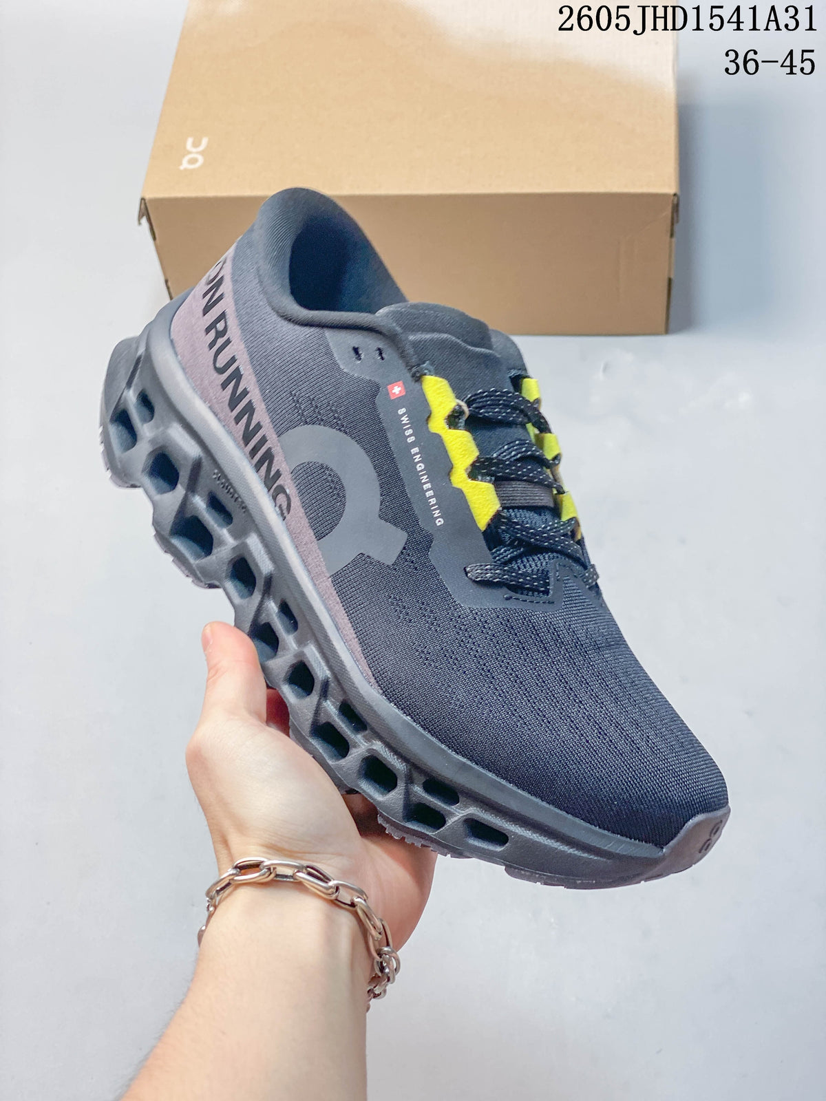 Angled view of a charcoal On running shoe with yellow lace accents and heel branding.