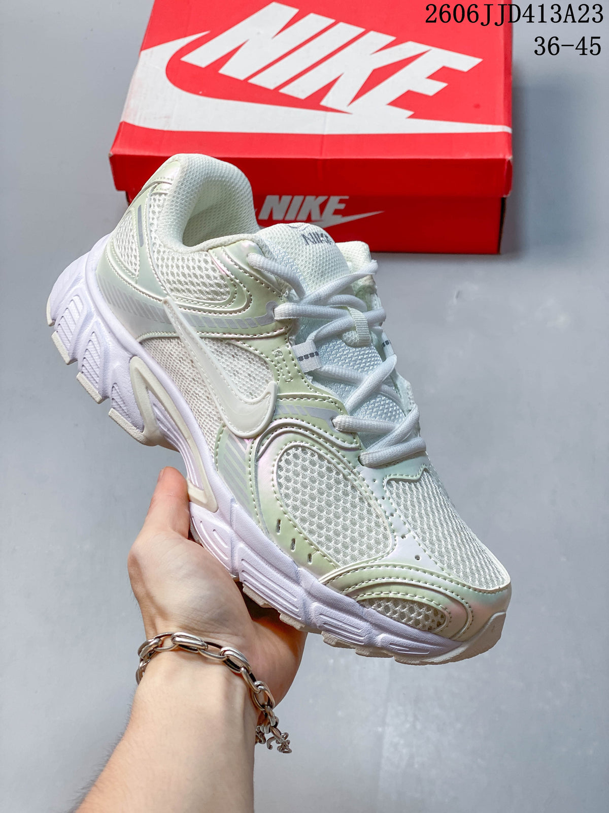 Angled side view of a light-colored Nike Air Zoom Winflo 12 shoe with mesh panels and a sculpted outsole.