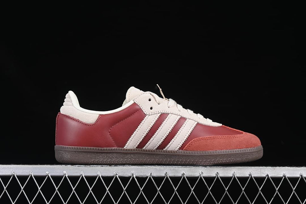 Side view of the burgundy and cream low-top sneaker
