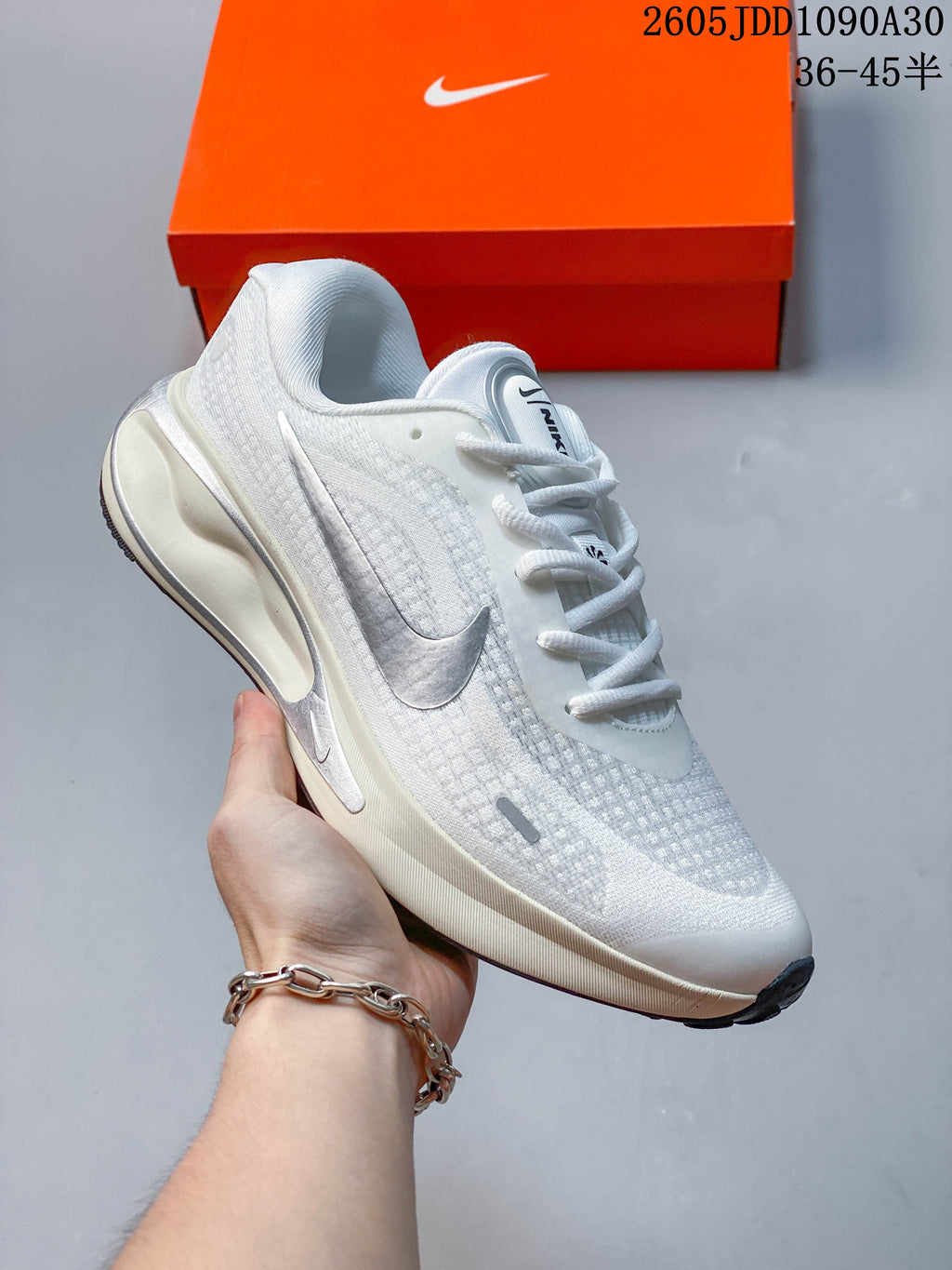 Side view of a white Nike Journey Run shoe with gray accents and a cushioned-looking midsole.