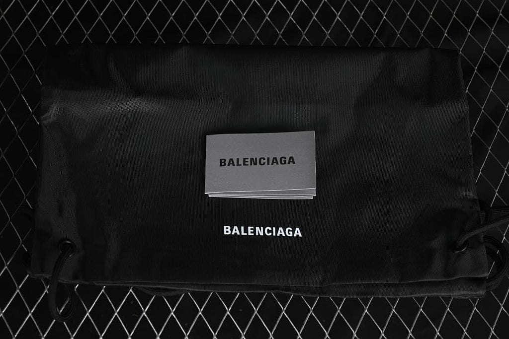 Black drawstring bag and booklet bearing Balenciaga branding.
