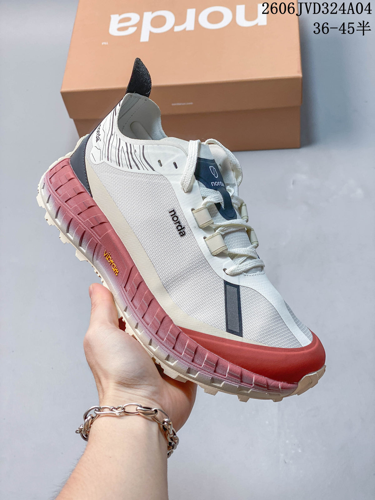 Side view of a white Norda sneaker with a rose-colored sole and dark accents.
