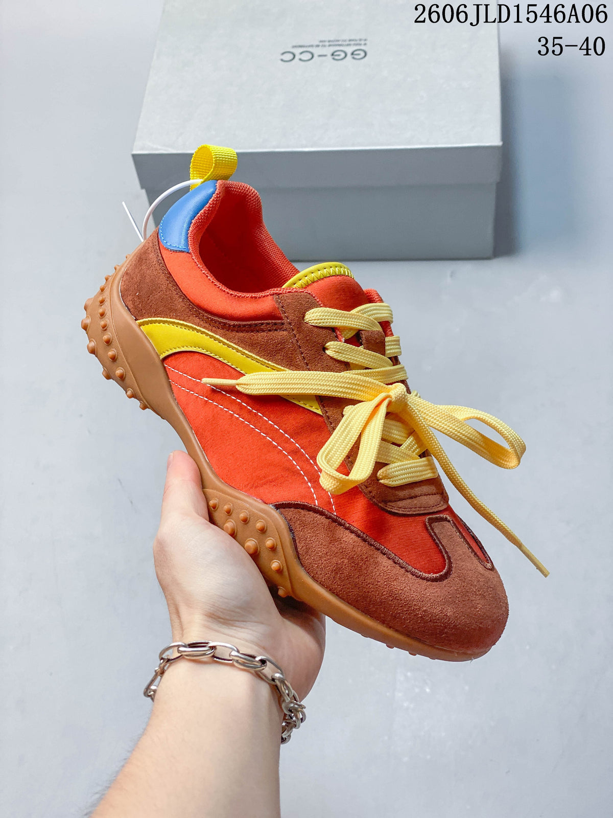 Angled view of the orange and brown sneaker with yellow laces and blue heel accents