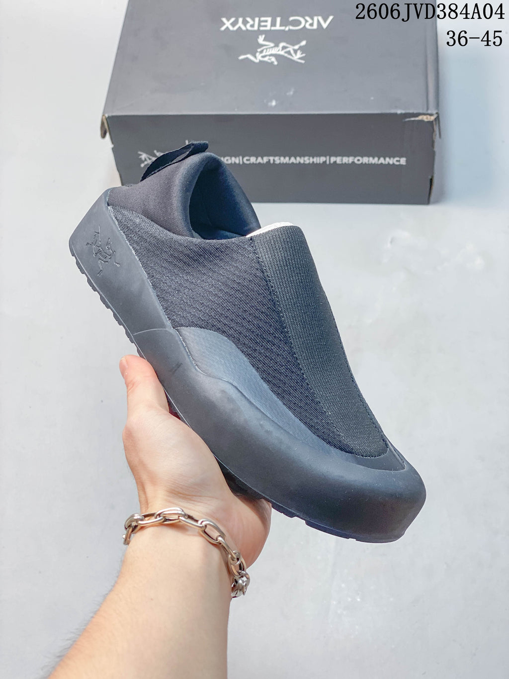 Angled view of a dark gray slip-on shoe with a heel pull tab