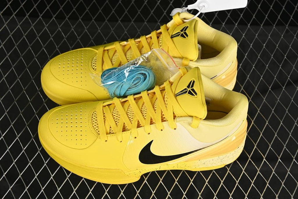 Pair of yellow Kobe 4 shoes with an extra blue lace set