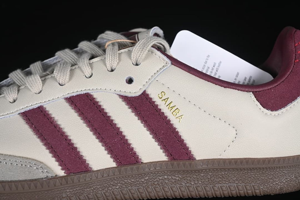 Close-up of burgundy side stripes, cream upper, laces, and Samba lettering.