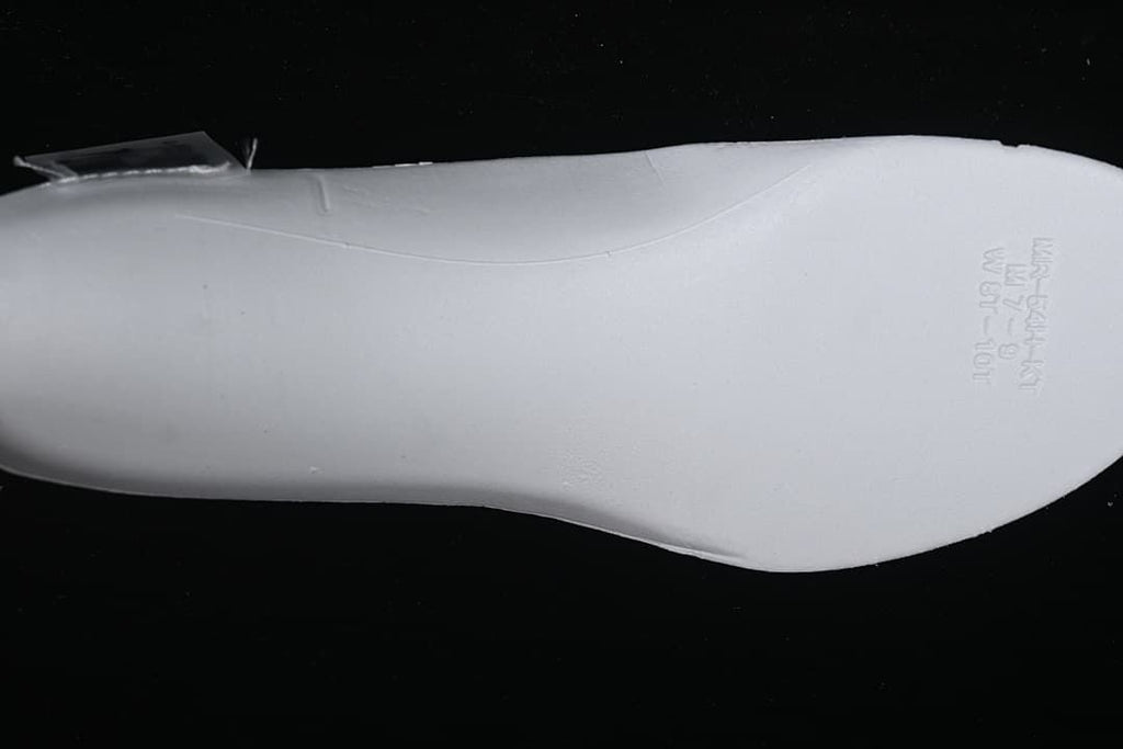 Underside view of the white shoe's insole with printed markings