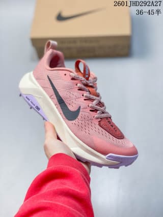 Pink Nike trail running shoe with a dark Swoosh, pale midsole, and purple outsole accent.