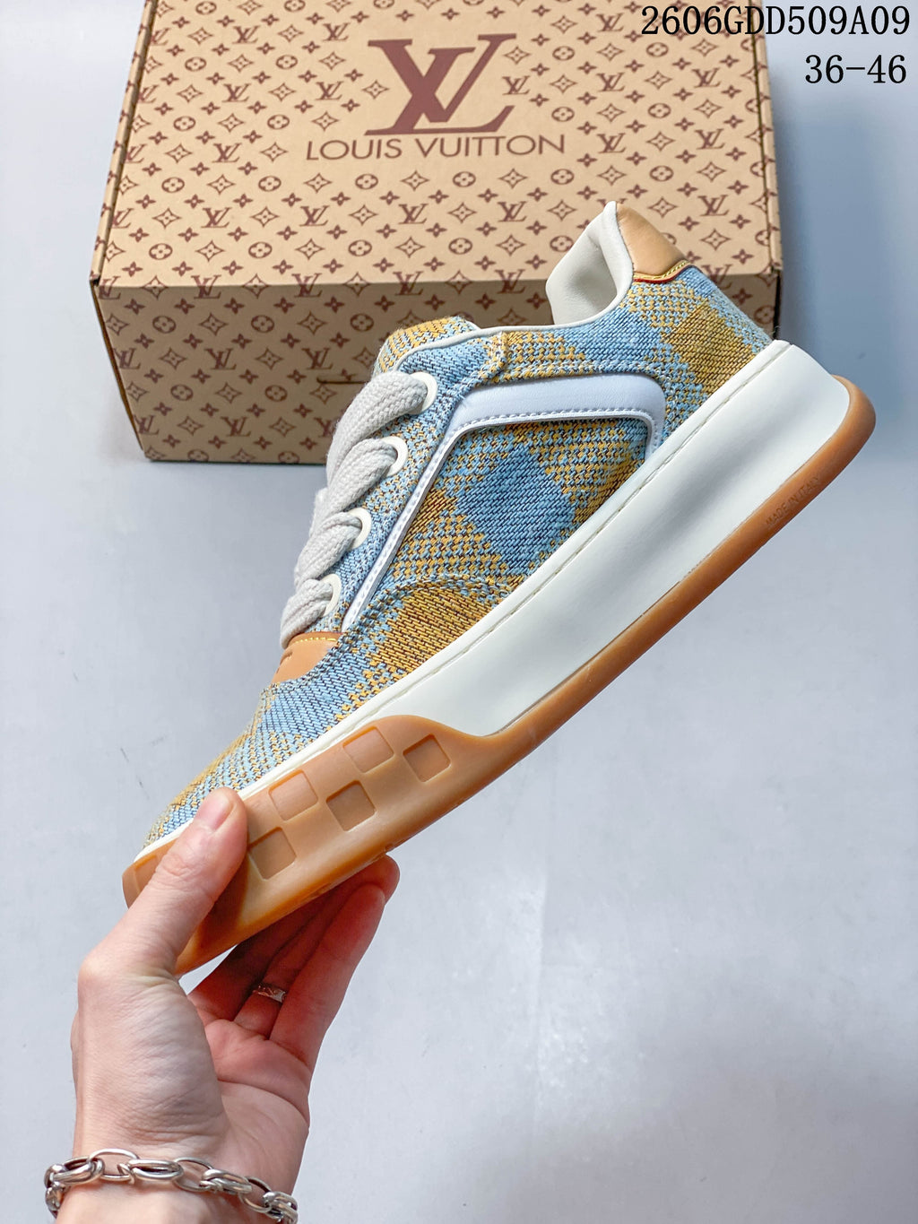 Side view of blue and tan check-patterned low-top sneaker with white midsole and tan outsole.
