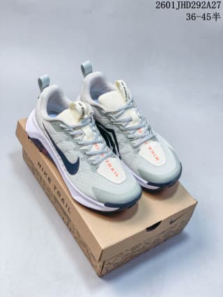 Pair of pale green and white Nike trail sneakers displayed on a Nike shoe box.