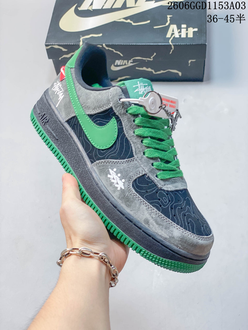 Angled side view of the gray, navy, and green Nike Air Force 1 sneakers