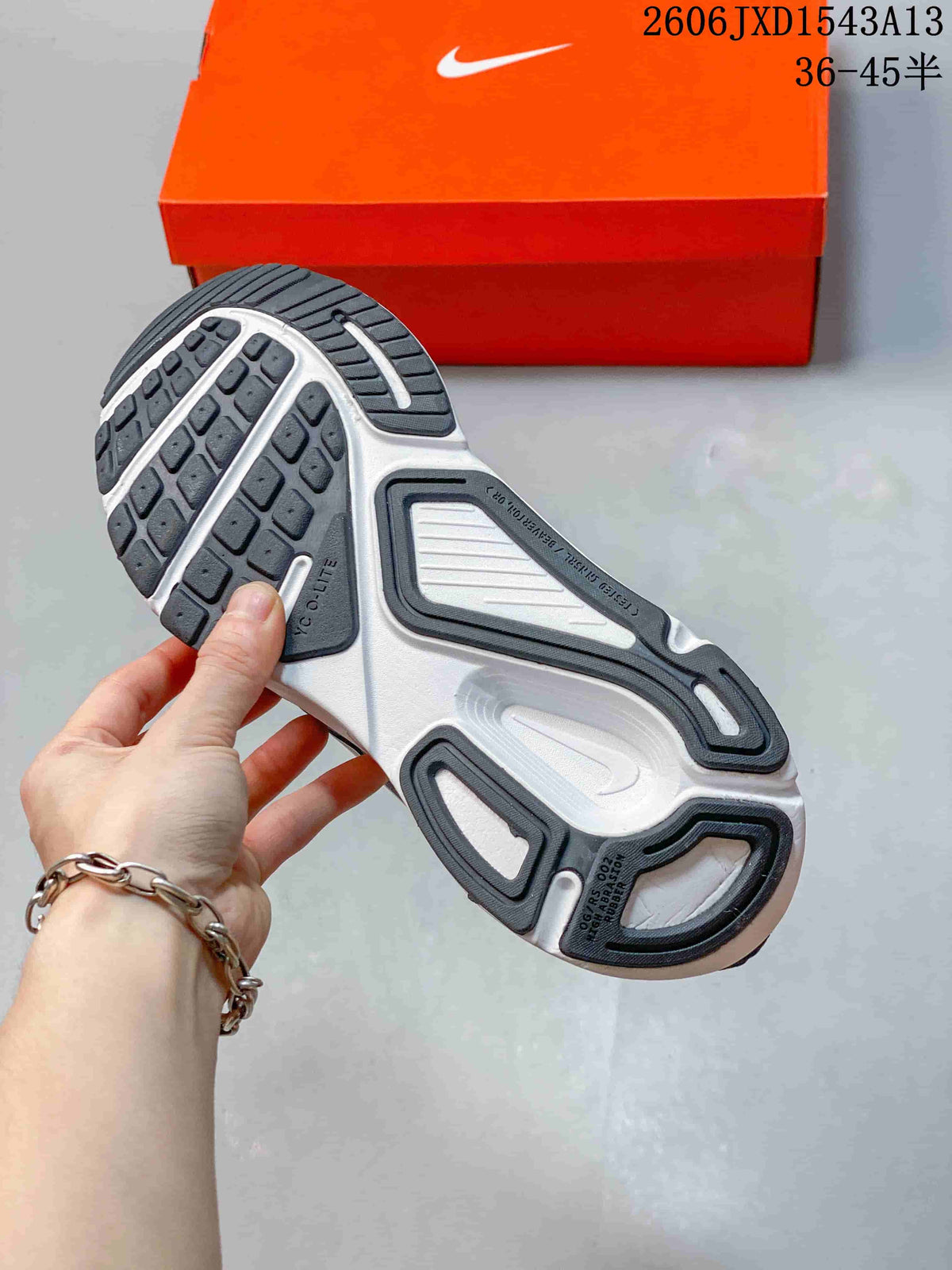 View of the running shoe outsole, showing dark tread and a light-colored midsole.