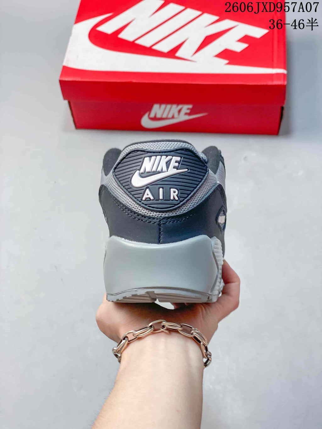 Rear view of a Nike Air Max 90 sneaker showing the heel branding and gray midsole.