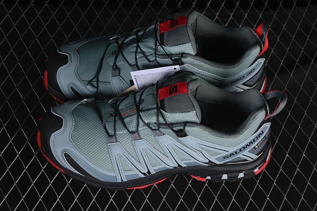 Pair of gray, black, and red Salomon trail shoes