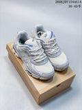 Pair of white and grey ASICS GEL-NYC sneakers with blue accents, shown from above on a shoebox.