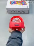Rear view of a red Nike Mind slide held in front of its shoe box, showing the heel and rounded outsole.