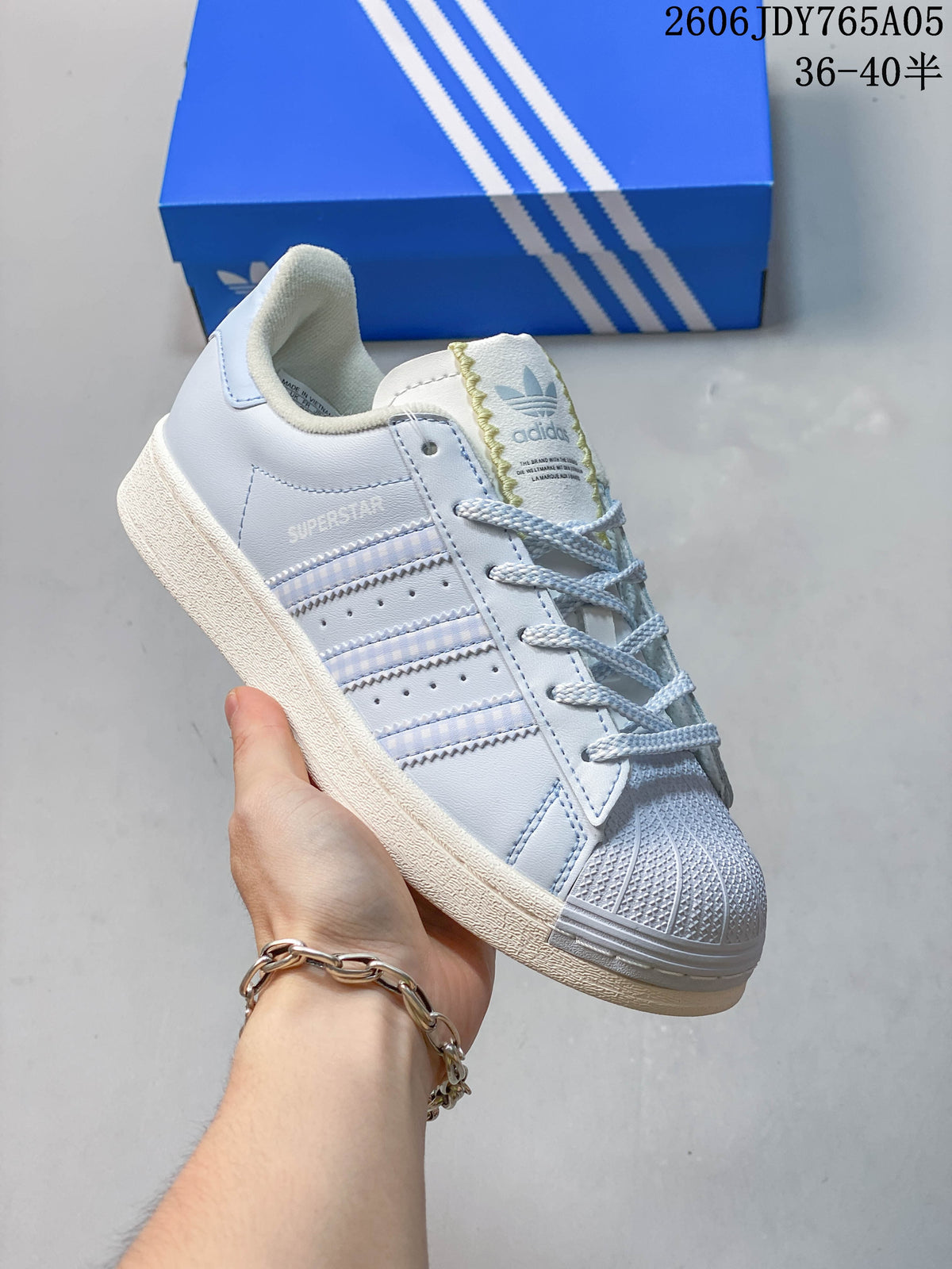 Angled side view showing the Superstar branding and stripe details