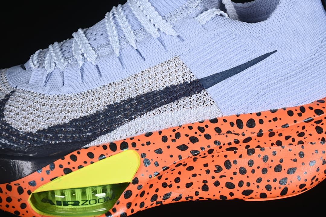 Close-up of the side Swoosh, speckled orange sole, and lime heel cushioning detail.