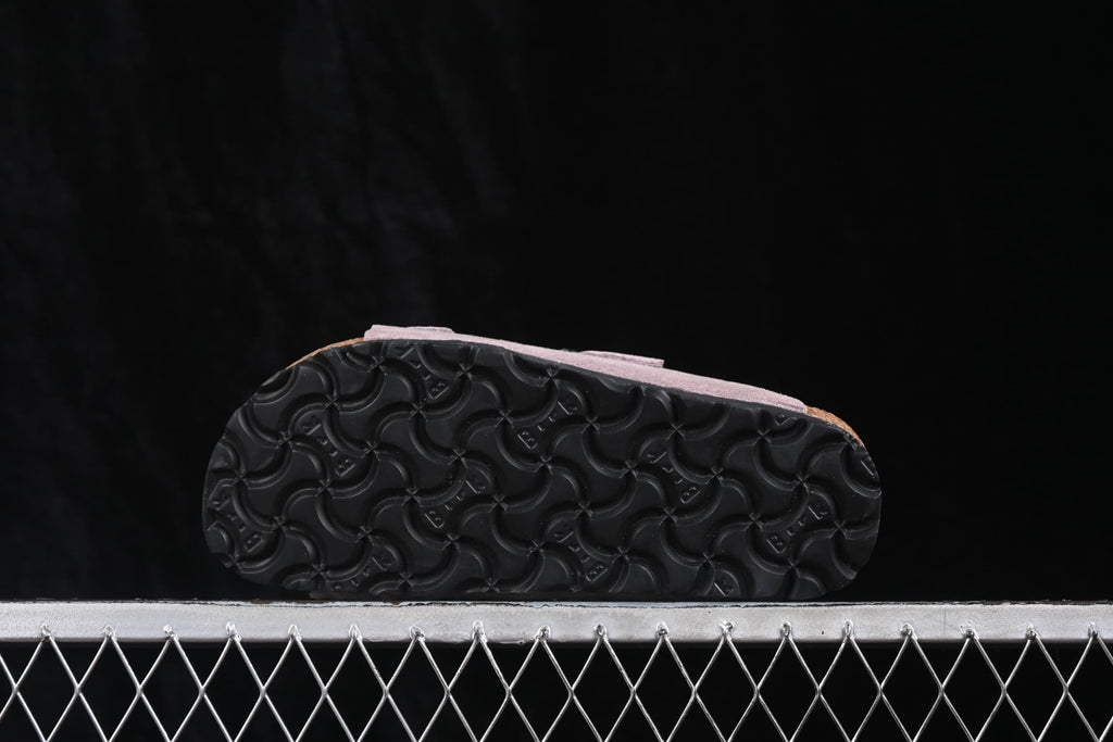 Close view of the black patterned outsole on a lavender sandal.