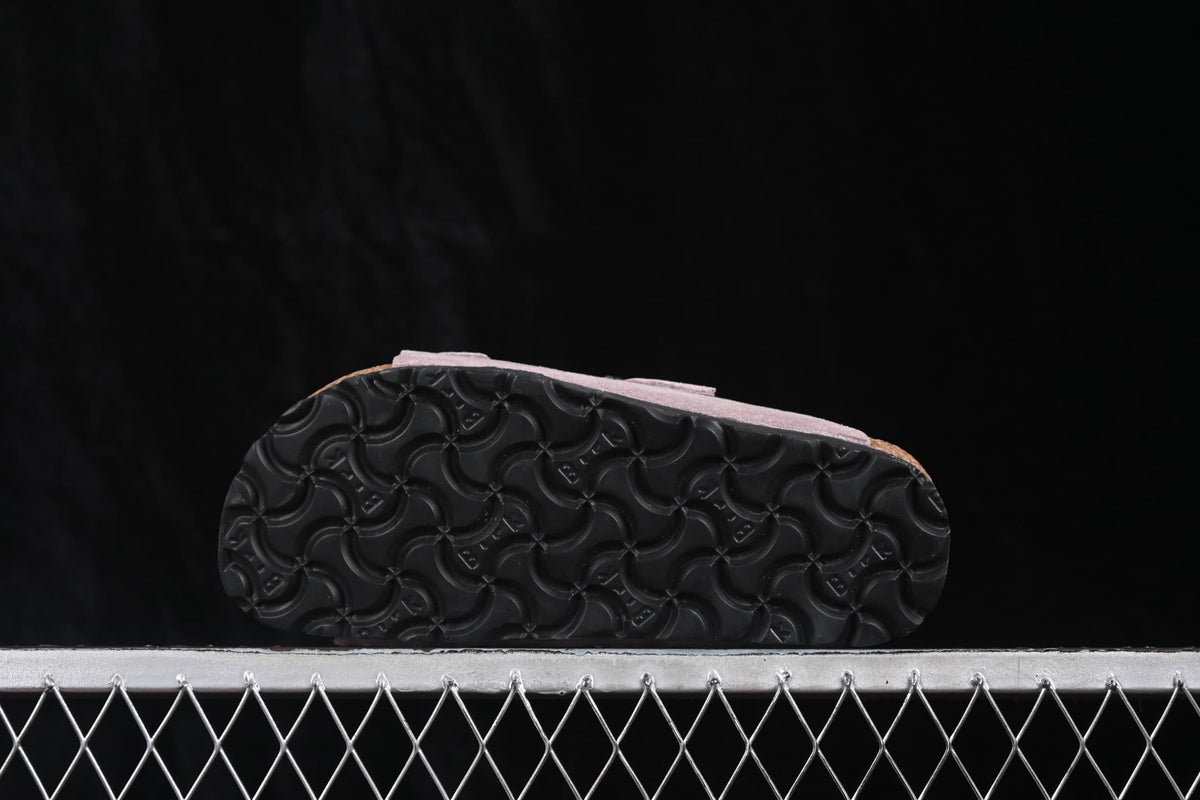 Close view of the black patterned outsole on a lavender sandal.