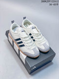Pair of white Adidas Originals VS Jog 2.0 low-top sneakers with dark stripes, gray overlays and gum-colored soles on a shoebox.