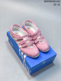 Pair of pink Adidas Samba Vegan OG strap sneakers on a blue box