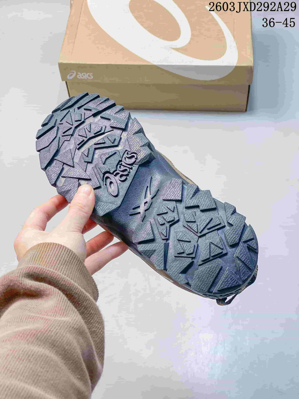 Close-up of the deeply patterned dark outsole on an ASICS Gel-Pickax sneaker.