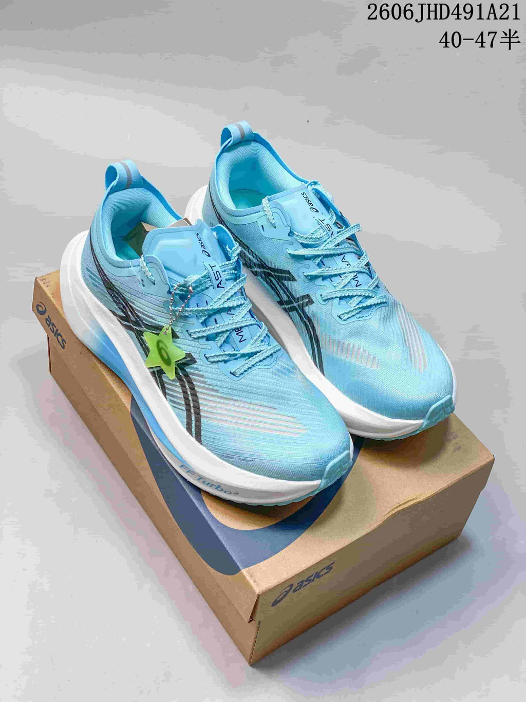 Pair of light blue ASICS MEGABLAST running shoes on a shoebox