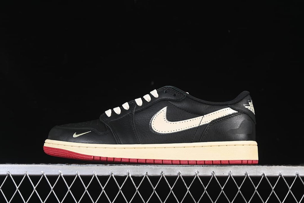 Side profile of a black Air Jordan 1 low-top with sail accents and a red outsole