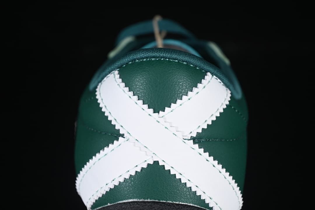 Rear view highlighting the white crossed heel panels on the green sneaker.