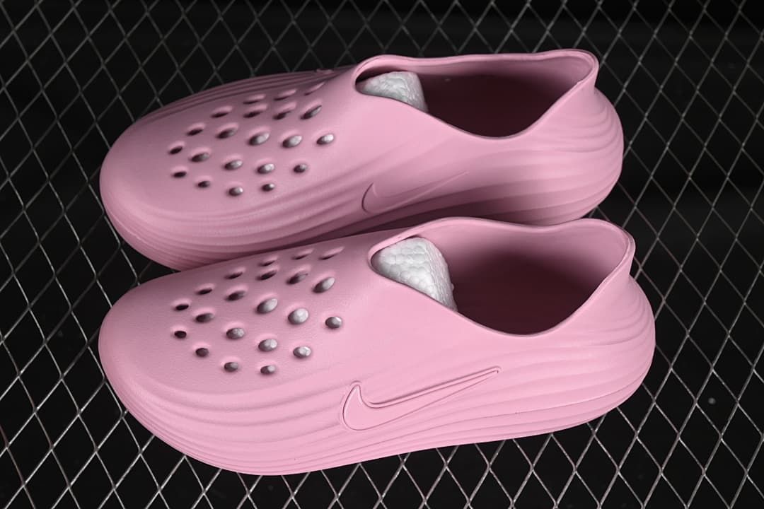 Pair of pink perforated slip-on shoes shown from an angled top and side view.