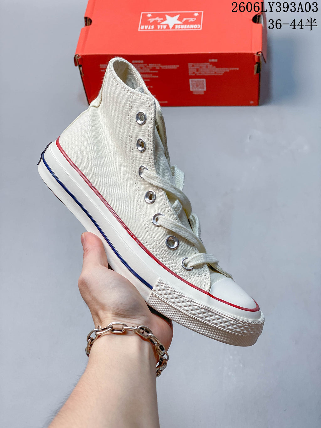 Off-white high-top sneaker with red and navy trim along the rubber sole